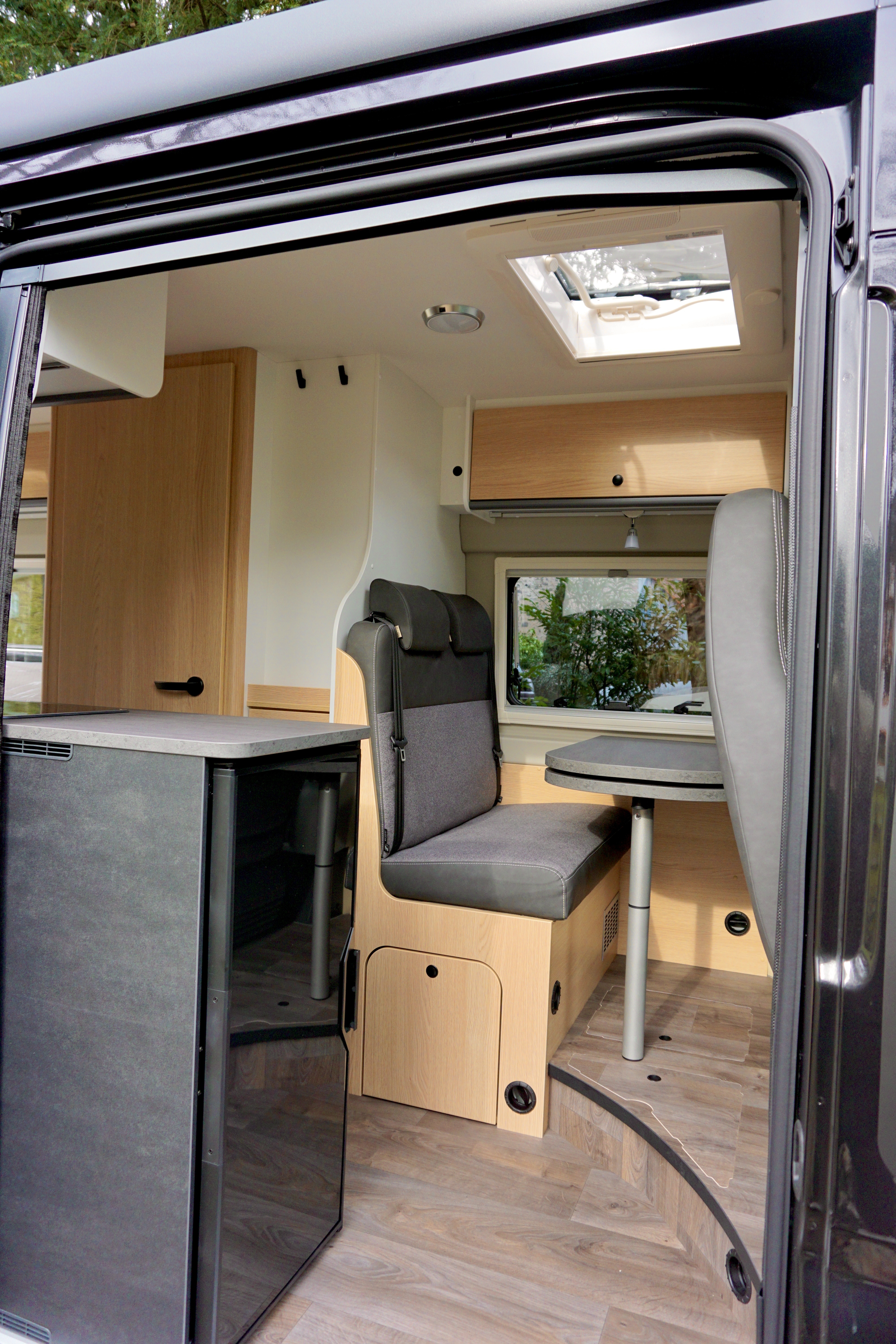 Van von innen mit Blick auf Sitzecke und Esstisch. Bild durch Schiebetür seitlich fotografiert.