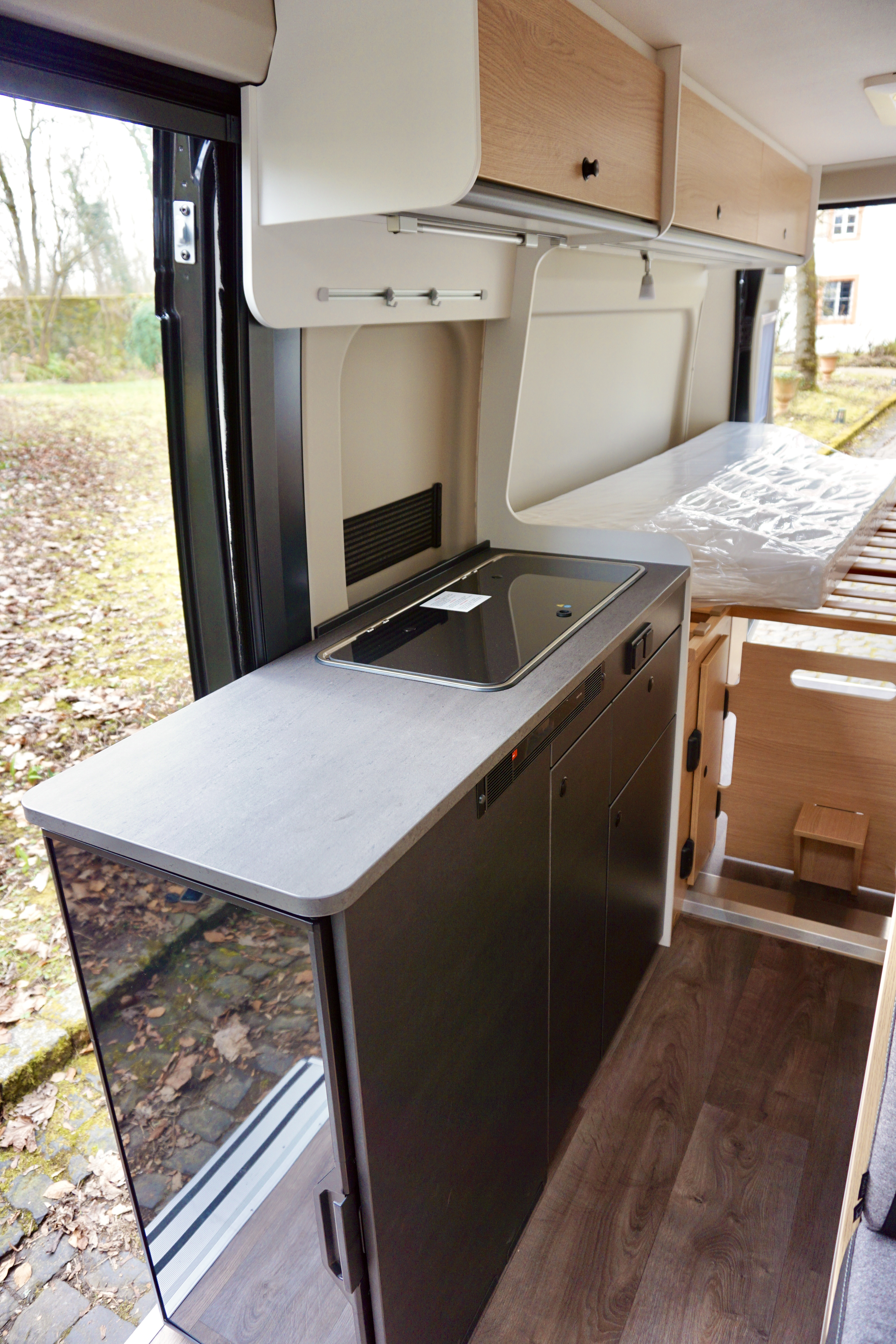 Küchnzeile innen mit Herd und Kühlschrank.