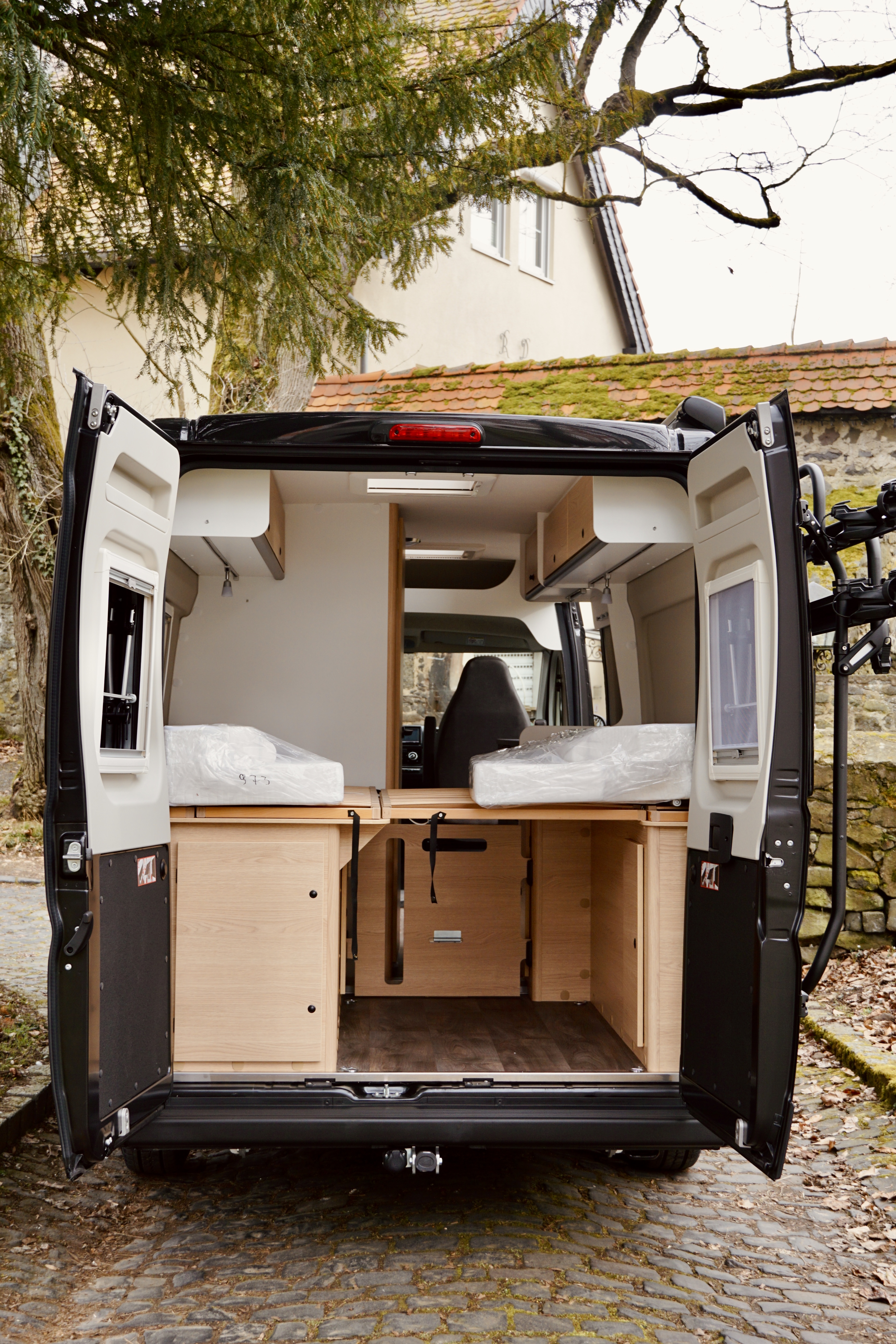 Blick von außen durch die Hintertür des Vans auf den Schlafbereich